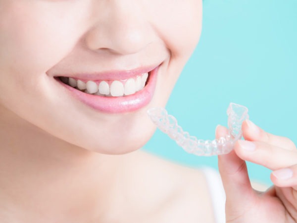 Woman holding a clear invisible aligner